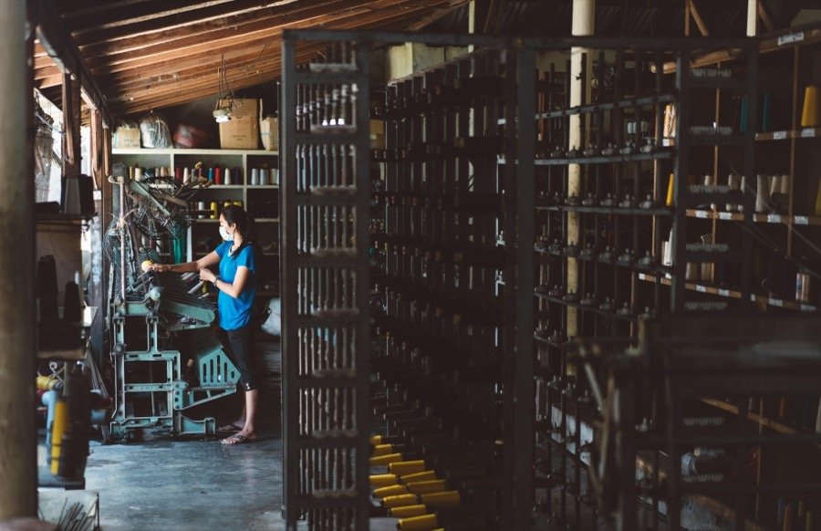 Textile factory worker operating a loom